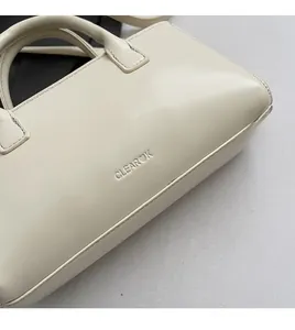 Vue détaillée du sac à main en cuir ciré crème avec logo Clearok embossé sur le devant