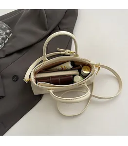 Vue de dessus montrant la grande capacité intérieure du sac à main en cuir ciré crème