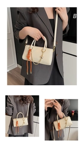 Détail du sac à main en cuir blanc cassé avec foulard orange et chaîne cœur dorée