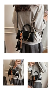 Vue détaillée d'un sac à main en cuir noir avec chaîne dorée et pendentif coeur
