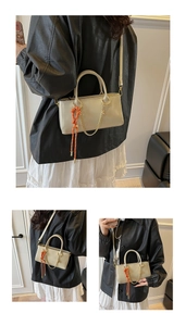 Détail d'un petit sac carré en cuir ciré crème avec pendentif en corde tressée orange