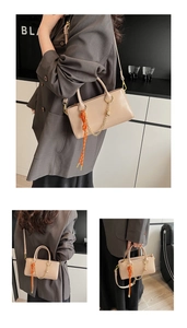 Détail du sac à main en similicuir beige avec chaîne dorée et foulard en soie à fleurs