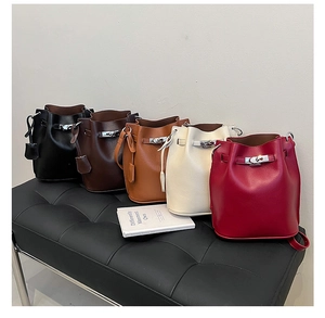 Close-up of litchi texture bucket bags in multiple colors with silver metal twist lock