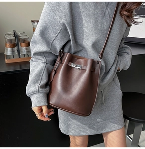 Detail of vintage brown bucket bag in lychee leather with classic metal swivel lock