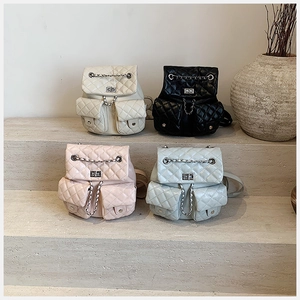 Quilted mini backpacks in four colors displayed on stone steps with chain details