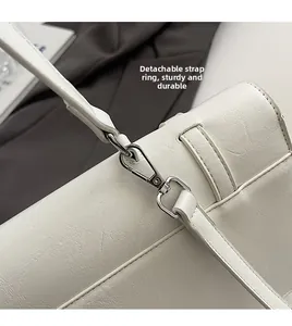 Detail of silver detachable metal ring and durable hardware on white shoulder bag