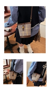 Detailed view of vintage plaid bucket bag featuring leather trim and metal clasp closure