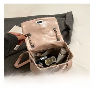 Detail of light pink quilted backpack interior showing spacious storage and silver hardware