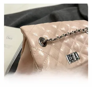 Detail of pink quilted leather bag featuring silver twist lock and chain strap hardware