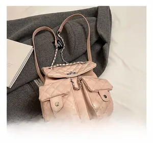 Detailed view of pink quilted backpack featuring chain straps and dual front pockets