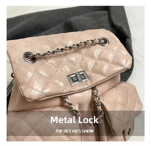 Close-up of polished silver hardware lock and quilted pink faux leather texture