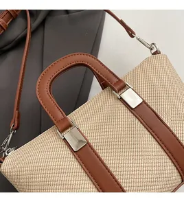 Detail of woven fabric texture and brown leather strap with silver metal buckles on bucket bag