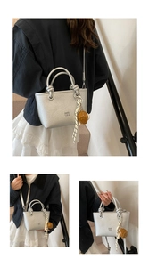 Borsa a mano alla moda argentata da donna, elegante borsa secchiello con manico e ciondolo orsetto.