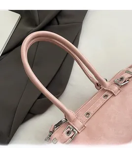 Close-up of the smooth pink leather handle with silver metal buckle and fine stitching