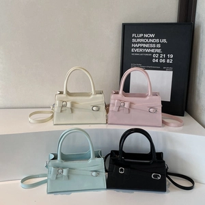 Minimalist square tote bag with belt buckle detail in various colors shown from front angle