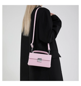 Rückansicht eines Models mit einer rosa Umhängetasche mit silbernem Metalldruckverschluss