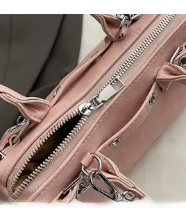 Close-up of smooth silver metal zipper on a premium pink matte leather Boston handbag