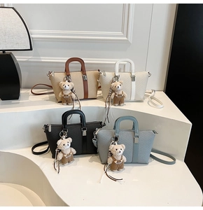 Detail shot of four woven bucket bags in various colors with cute bear pendants