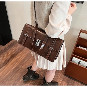 Detailed view of the dark brown leather texture and metal buckle on the vintage handbag