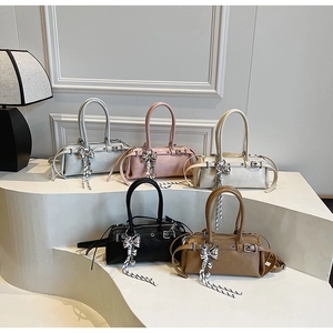 Five elegant Boston handbags in various colors featuring striped bow charms and sleek straps