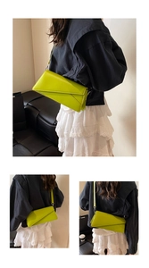 Détail du sac bandoulière en cuir vert néon avec rabat géométrique et boucles argentées