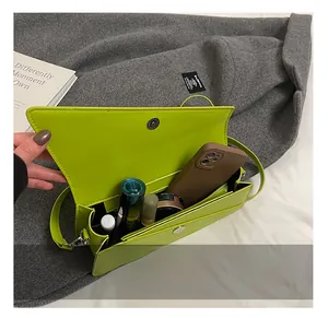 Interior capacity of neon green faux leather shoulder bag with phone and cosmetics