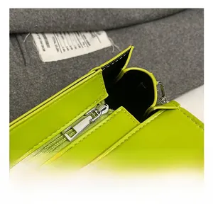 Close-up of neon green leather bag featuring high-quality silver zipper and neat stitching