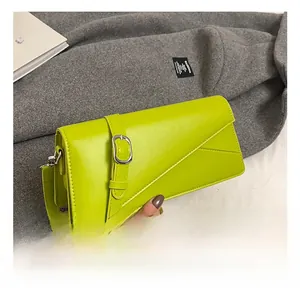 Detail of neon green leather shoulder bag with geometric flap and silver buckle accent