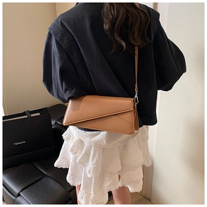 Rear view of a chic brown PU leather crossbody bag worn by a model in a trendy outfit