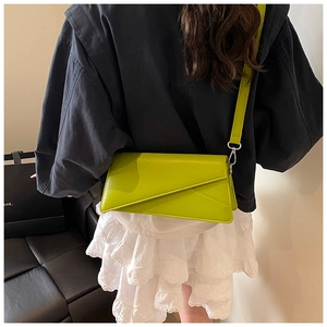 Détail du sac à bandoulière géométrique vert citron avec mousqueton argenté sur l'épaule