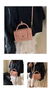 Detail showing pink glossy leather mini square bag with silver logo and top handle