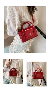 Detail of glossy red oil wax leather handbag showing smooth finish and logo texture