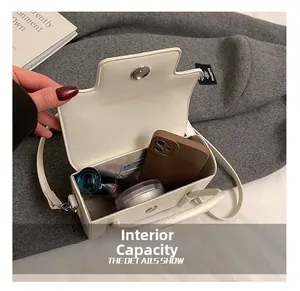 Detailed interior of a white rectangle handbag showing storage space for cosmetics and phone