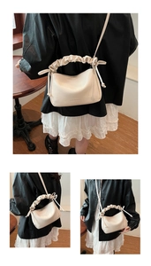 Detail showing creamy white pleated pillow bag with drawstring bows and ruched handle