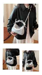 Macro shot of silver pleated handle bag with drawstring detail and branded embossing