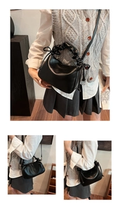 Detail of black cloud bag with scrunchie handle and drawstring side accents in soft leather