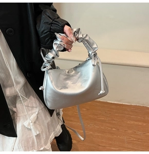 Detail of silver metallic pleated handle bag with matching crossbody shoulder strap