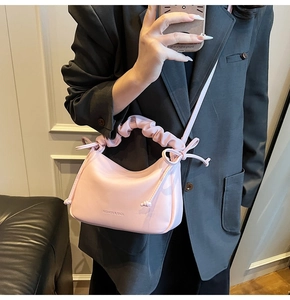 Pink cloud bag detail showing pleated handle and decorative side ribbon bows
