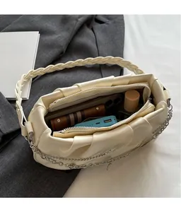 Interior detail of creamy pleated cloud bag showing spacious double zip compartments