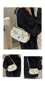 Détail du sac bandoulière plissé blanc cassé avec chaînes argentées et pendentif cœur