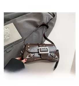 Détail macro du cuir synthétique marron foncé avec rivets argentés et boucle métallique