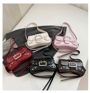 Overhead view showing diverse colors of studded moto-style shoulder bags with metal buckles