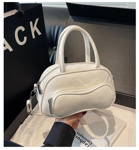 Macro detail of creamy white bowling bag with wave-pattern zipper and glossy faux leather texture