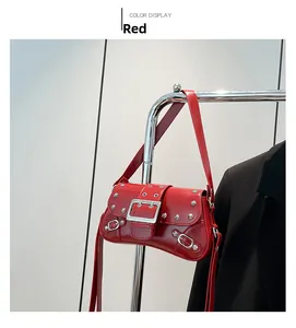 Détail du sac à bandoulière punk rouge avec rivets argentés et finition vernie