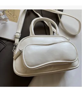 Detailed view of cream leather bowling bag with front pocket and adjustable strap