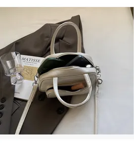 Top view of off-white crossbody bag showing double zipper compartments and interior space
