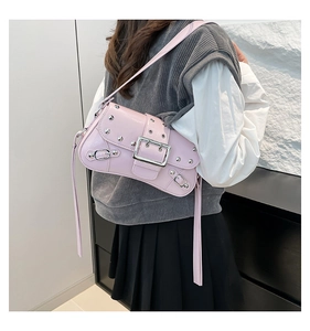 Détail d'un sac à bandoulière en similicuir rose avec rivets et boucle métallique