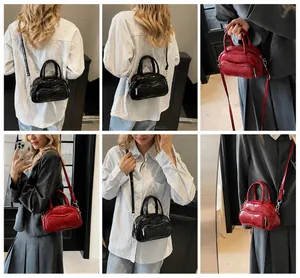 Detail view of mini leather bowling bags in red and black with wavy curve pocket design