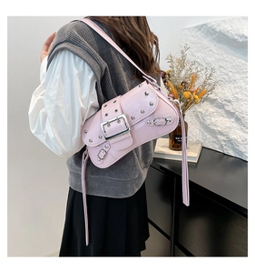Detail view of pink punk shoulder bag with silver rivets and zippers on a female model