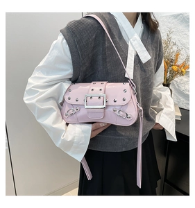 Détail du sac à bandoulière rose avec clous argentés et une grande boucle métallique